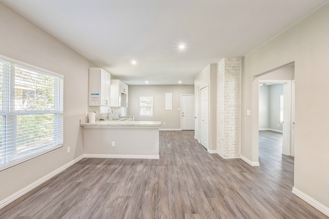 kitchen featuring sink, dark wood-type flooring, white cabinetry, and kitchen peninsula