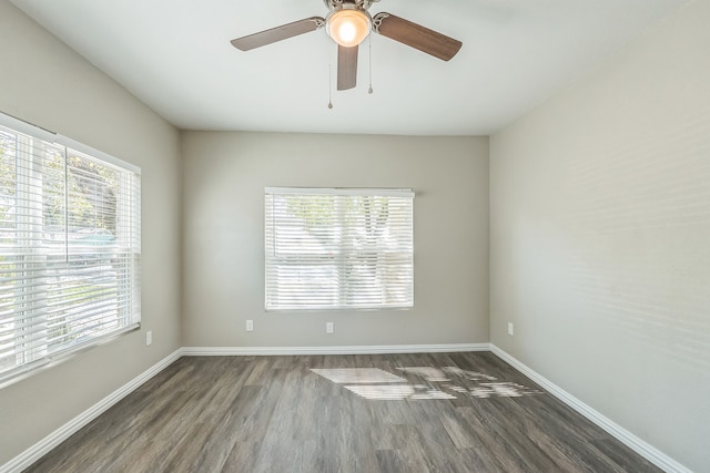 empty room featuring dark hardwood / wood-style floors, a healthy amount of sunlight, and ceiling fan