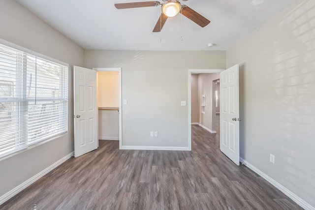 interior space with dark hardwood / wood-style flooring, multiple windows, and ceiling fan