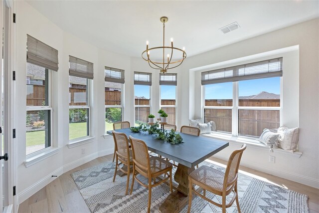 dining area with a notable chandelier and light hardwood / wood-style flooring