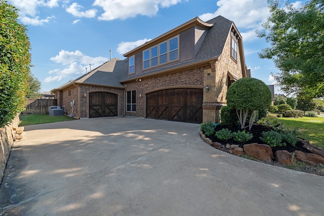 view of front facade with a garage and central AC