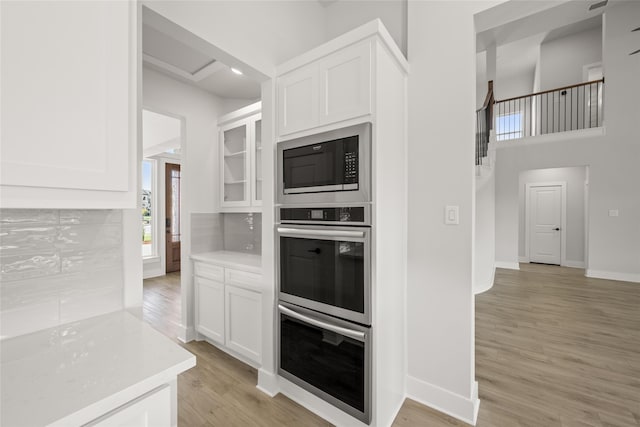 kitchen with light hardwood / wood-style flooring, stainless steel appliances, and white cabinetry