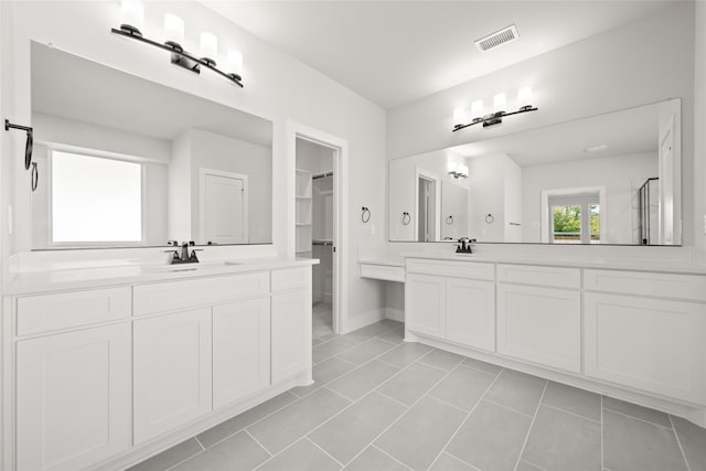 bathroom with tile patterned floors, vanity, and a shower