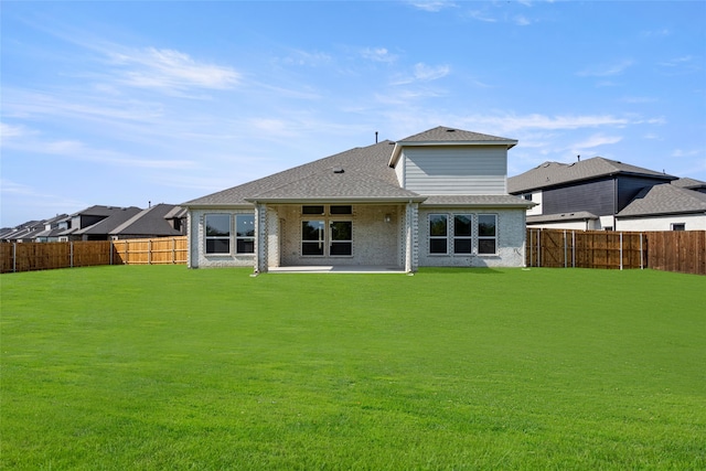 back of house featuring a lawn and a patio area