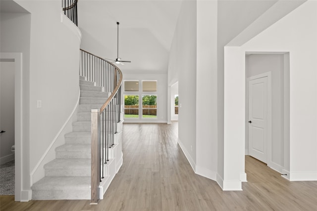 entryway featuring light wood-type flooring, high vaulted ceiling, and ceiling fan