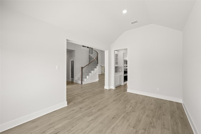 unfurnished room featuring light hardwood / wood-style flooring and lofted ceiling