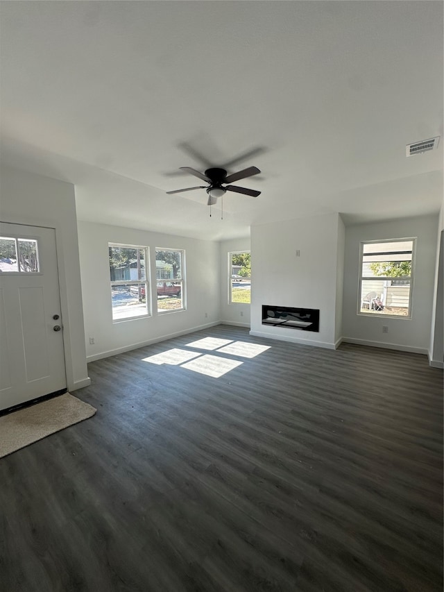 unfurnished living room featuring dark hardwood / wood-style flooring, ceiling fan, and a wealth of natural light