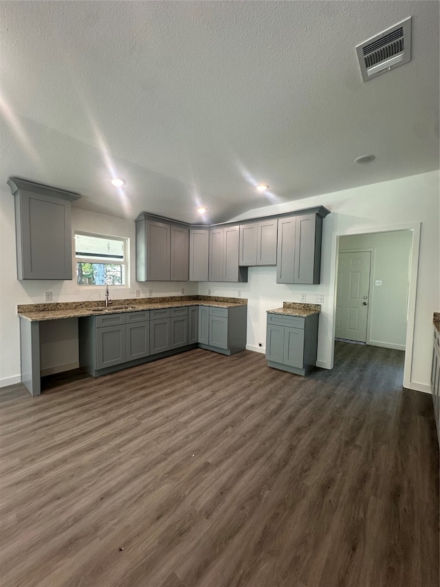 kitchen featuring dark hardwood / wood-style floors, a textured ceiling, and gray cabinetry