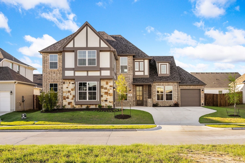 view of front of property featuring a garage and a front lawn