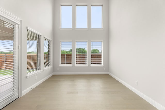 1008 Roys Dr, Rockwall, TX 75087 - spare room with light wood-style flooring, baseboards, and a high ceiling
