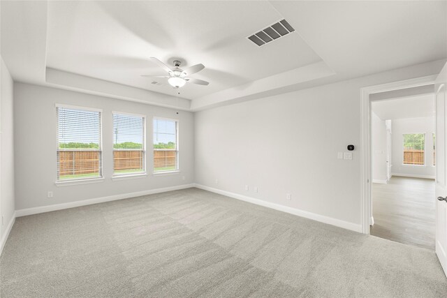 1008 Roys Dr, Rockwall, TX 75087 - carpeted empty room featuring a tray ceiling, ceiling fan, plenty of natural light, and baseboards
