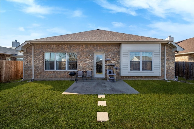 back of house featuring a lawn and a patio area