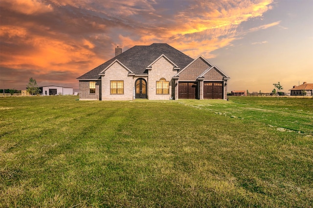 view of front of home featuring a garage and a lawn