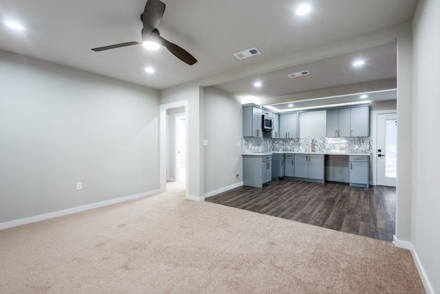 unfurnished living room featuring ceiling fan, dark wood-type flooring, and sink