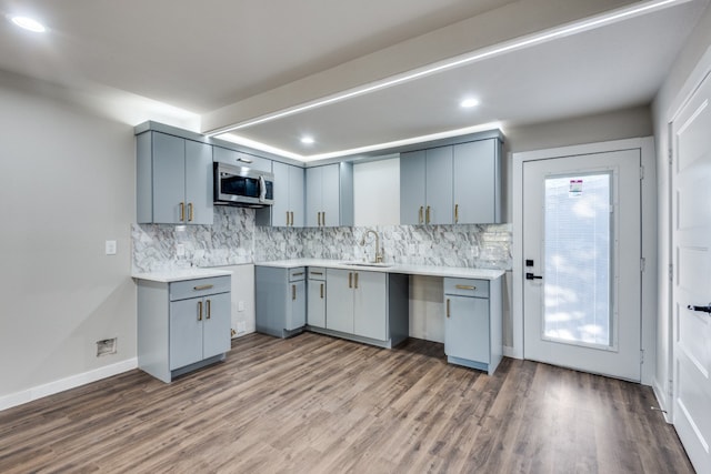 kitchen featuring gray cabinets, backsplash, dark hardwood / wood-style flooring, and sink