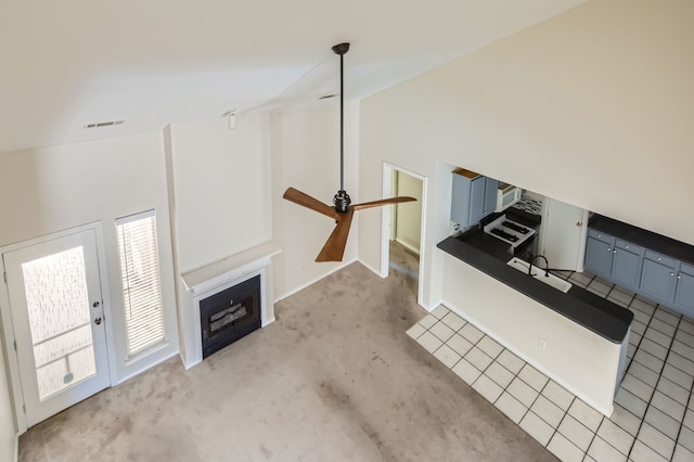 unfurnished living room with lofted ceiling, light carpet, ceiling fan, and sink