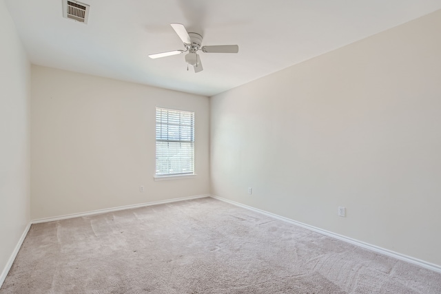 spare room with ceiling fan and light colored carpet