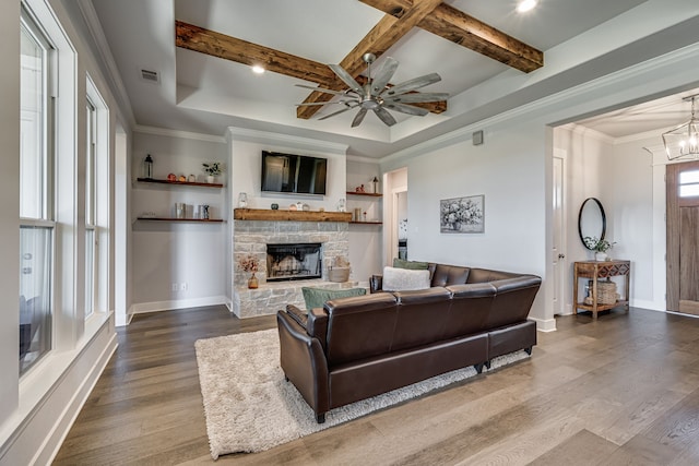 living room with ornamental molding, beam ceiling, hardwood / wood-style flooring, a fireplace, and ceiling fan with notable chandelier