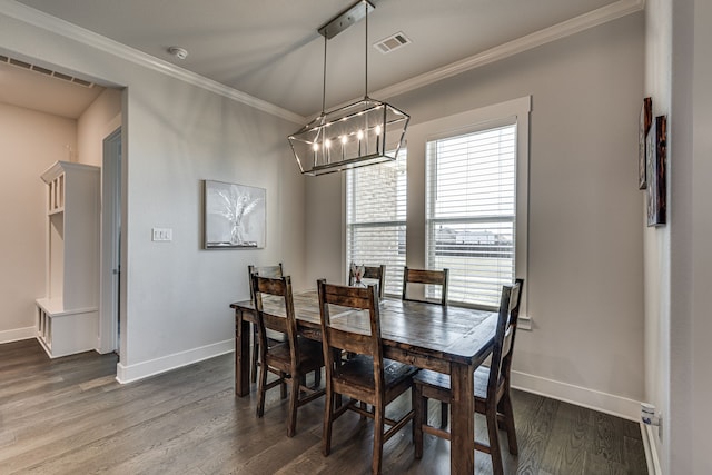 dining room with a chandelier, dark hardwood / wood-style floors, and crown molding