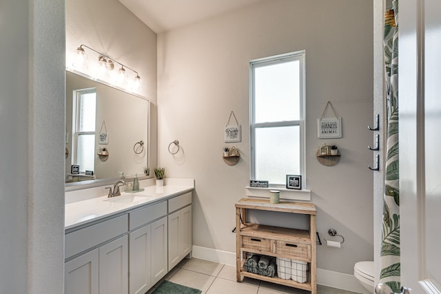 bathroom featuring a healthy amount of sunlight, tile patterned flooring, vanity, and toilet