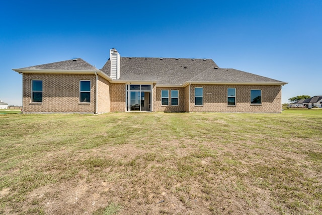 rear view of property with a yard