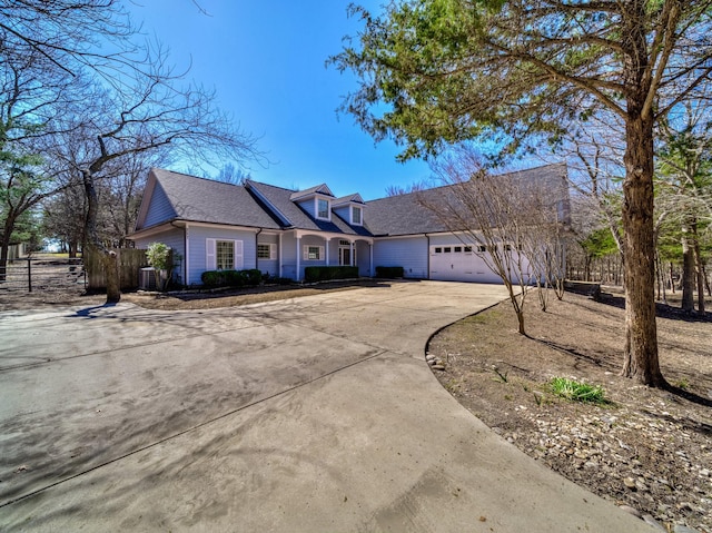 cape cod house with an attached garage, driveway, fence, and cooling unit