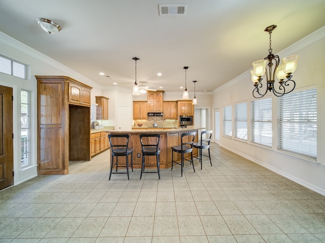 kitchen with visible vents, stainless steel microwave, backsplash, under cabinet range hood, and baseboards