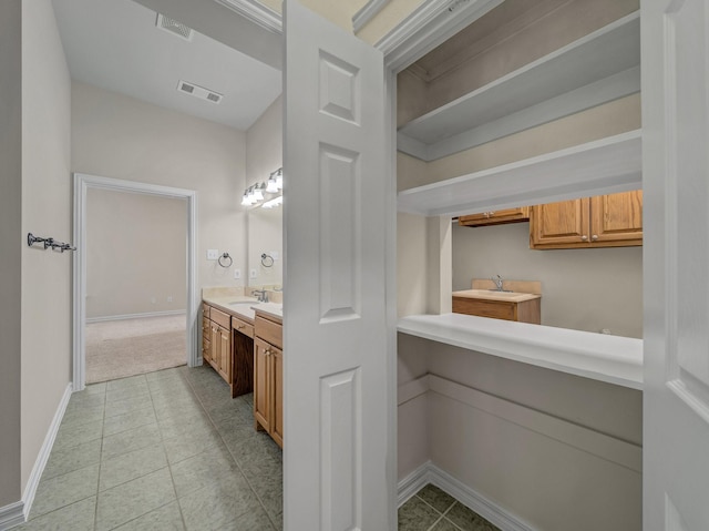 bathroom featuring tile patterned flooring, visible vents, vanity, and baseboards