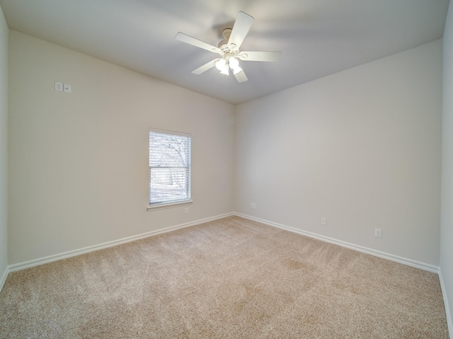 empty room with baseboards, a ceiling fan, and light colored carpet