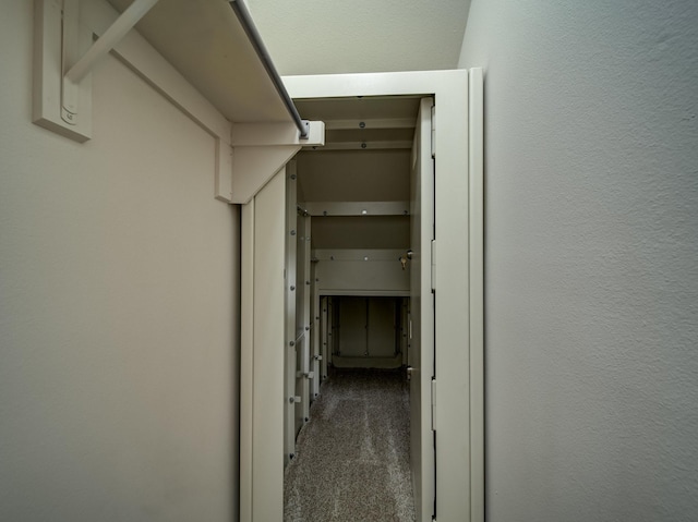 corridor with carpet flooring and a textured wall