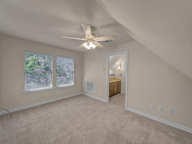 additional living space featuring light carpet, a ceiling fan, visible vents, vaulted ceiling, and baseboards