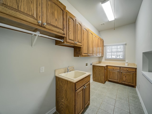 washroom featuring cabinet space, baseboards, washer hookup, and a sink