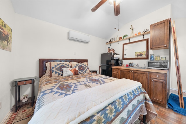 bedroom with light hardwood / wood-style floors, vaulted ceiling, ceiling fan, a wall mounted AC, and black refrigerator