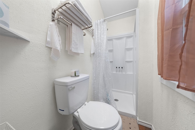 bathroom featuring toilet and a shower with curtain