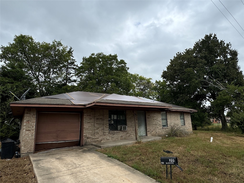 view of front of home with a front yard and a garage