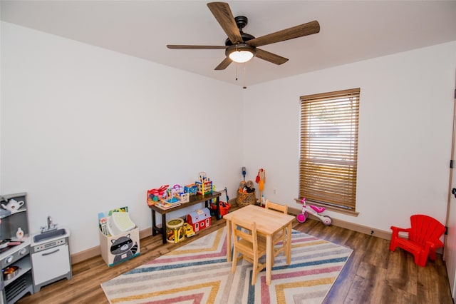 rec room featuring ceiling fan, baseboards, and wood finished floors