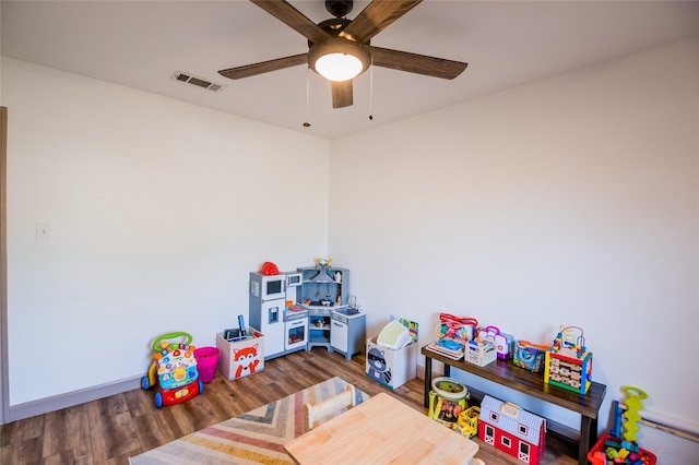 playroom with ceiling fan, wood finished floors, and visible vents