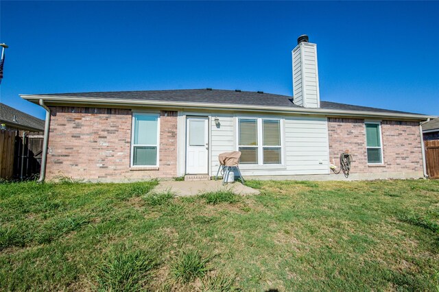 rear view of property with a lawn