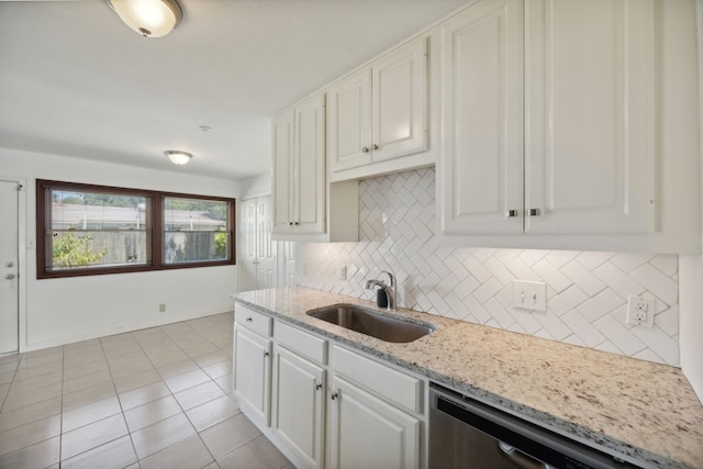 kitchen featuring light tile patterned floors, sink, white cabinetry, dishwasher, and decorative backsplash