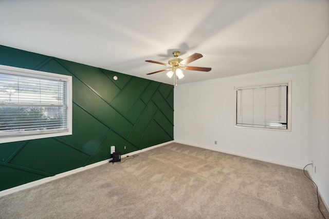 carpeted spare room with ceiling fan