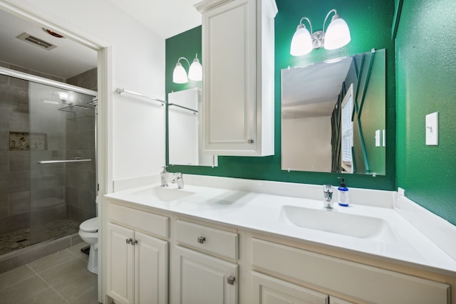 bathroom with vanity, toilet, tile patterned floors, and a shower with shower door