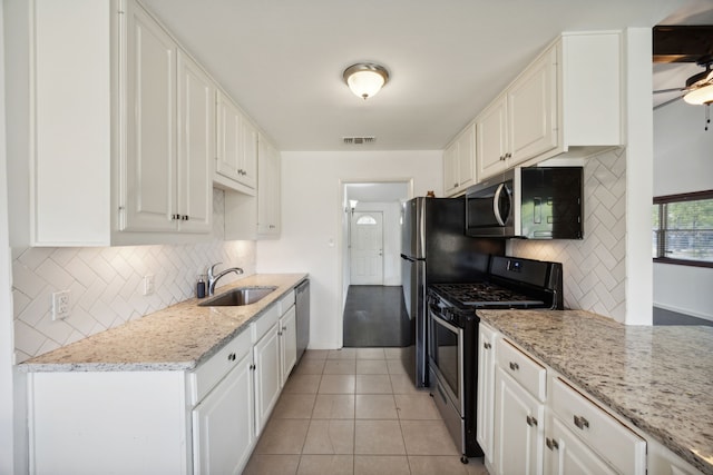 kitchen featuring sink, light tile patterned floors, stainless steel appliances, and white cabinets