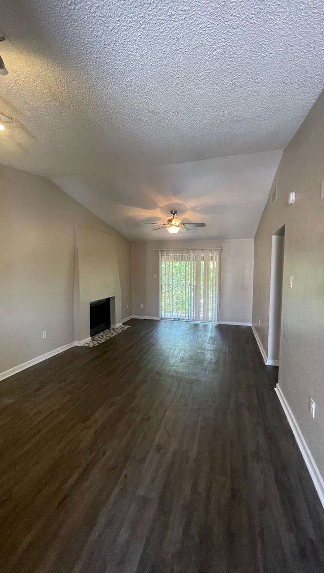 unfurnished living room with a textured ceiling, lofted ceiling, dark hardwood / wood-style flooring, and ceiling fan