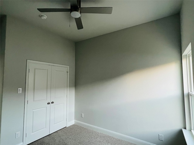 unfurnished bedroom with carpet, ceiling fan, and a closet