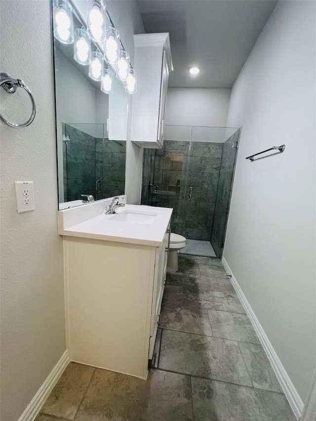 bathroom with a shower with door, vanity, and toilet