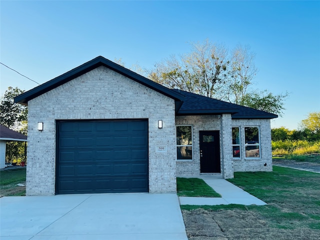 view of front of home with a front yard and a garage