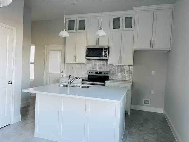 kitchen featuring white cabinets, a center island with sink, stainless steel appliances, and sink