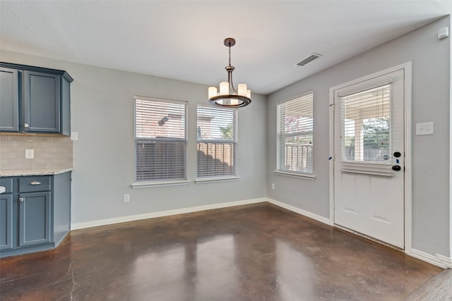 unfurnished dining area with a notable chandelier and a textured ceiling