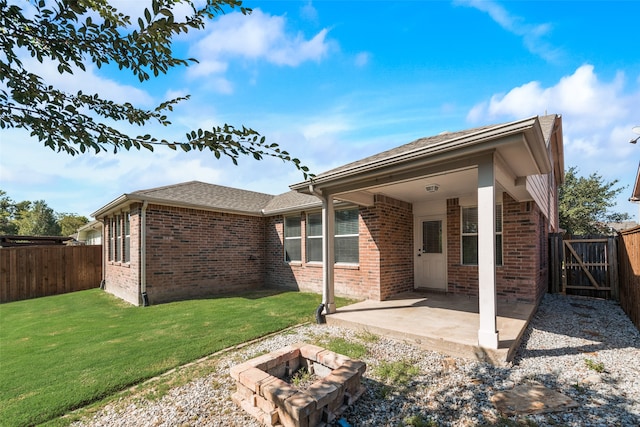 rear view of house with a patio and a lawn