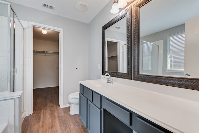 bathroom featuring walk in shower, vanity, toilet, and hardwood / wood-style flooring